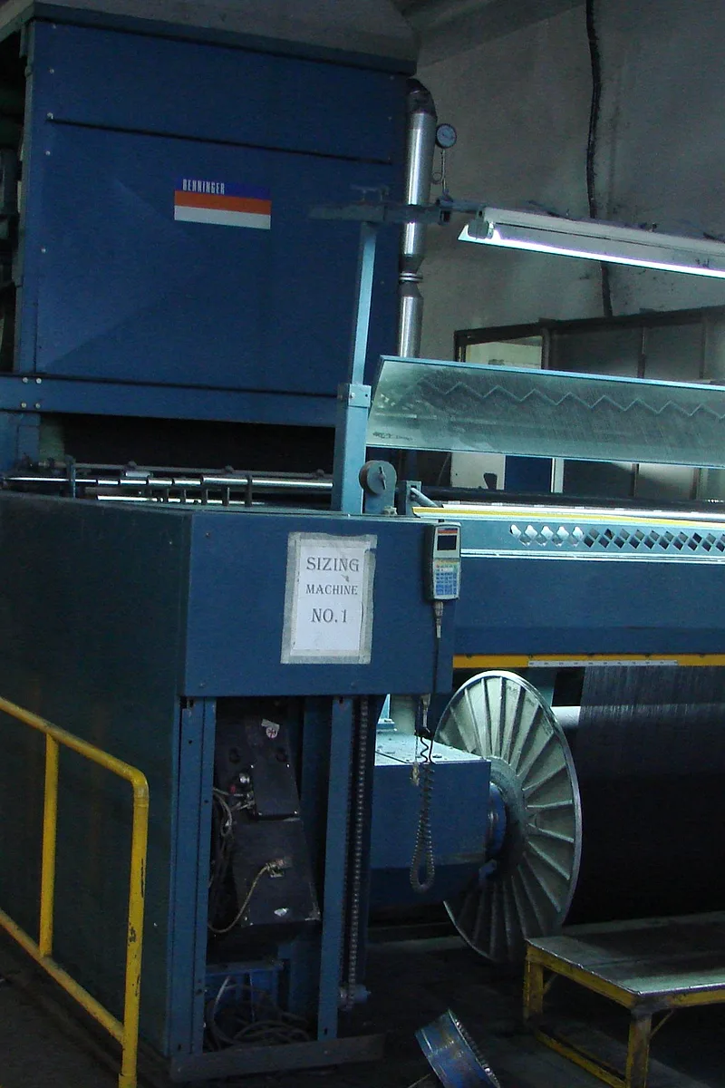 Sizing machine feeding dyed yarn onto a beam