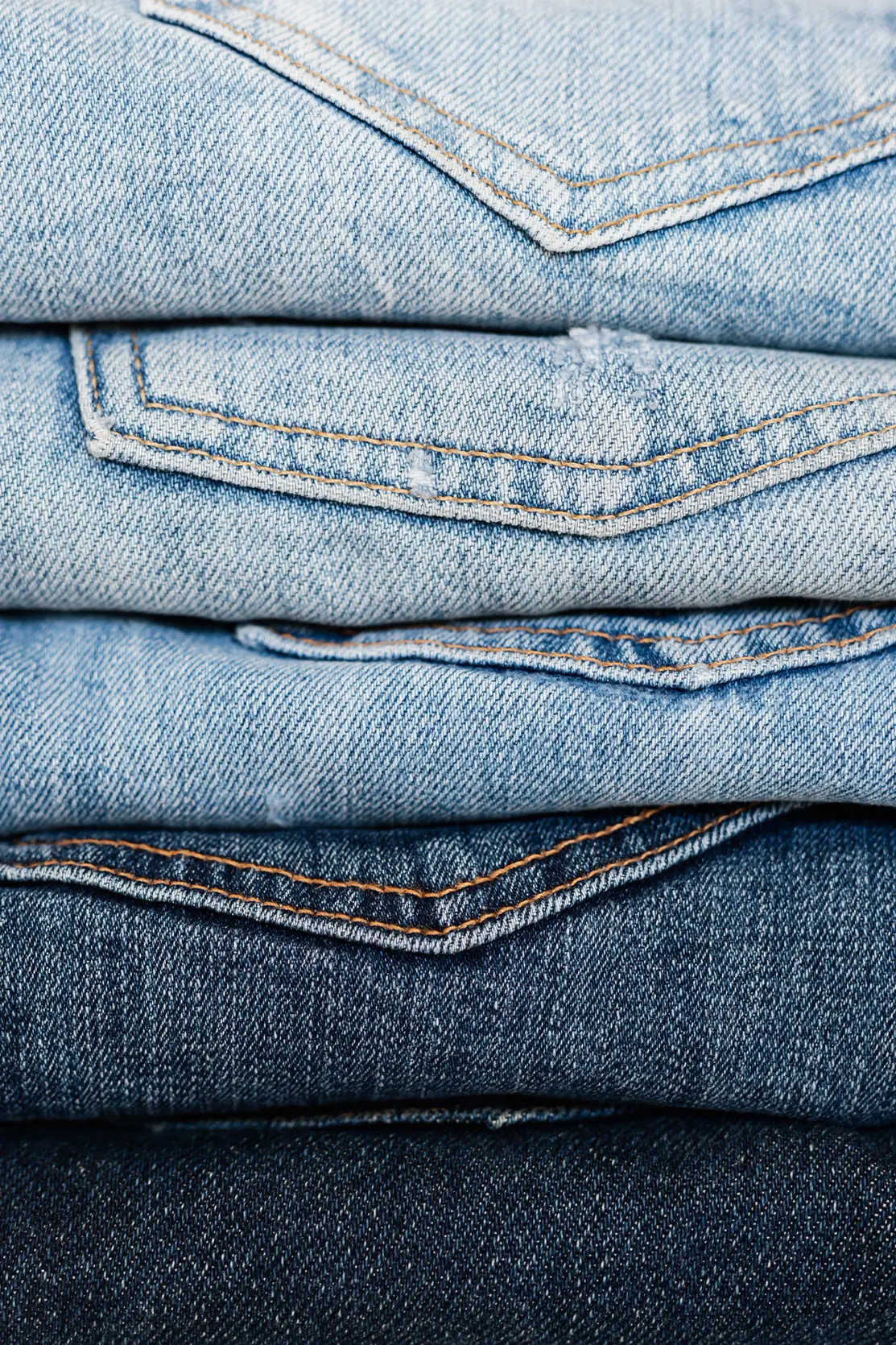 Folded jeans stacked from pale wash to dark indigo