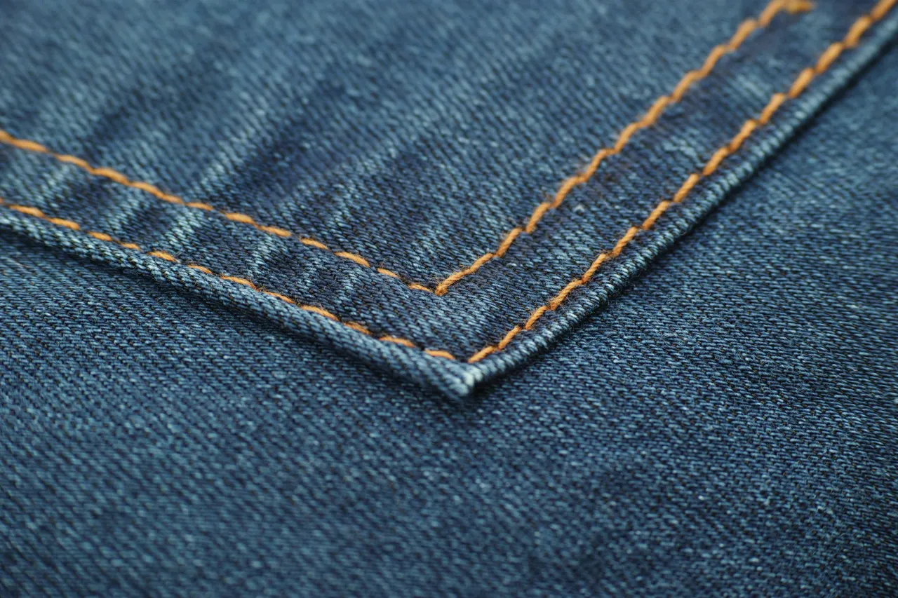 Contrast stitching along the edge of a denim panel